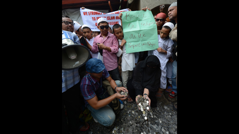 Philippine Muslims gather coins they collected from the provinces to be used to pay for filing a petition before the Philippine Supreme Court in Manila on Monday asking for local authorities to ban the controversial &quot;Innocence of Muslims&quot; film from being posted on the Internet.  Hundreds of Muslim protesters in the Philippines called for a ban on the film before the U.S. Embassy.