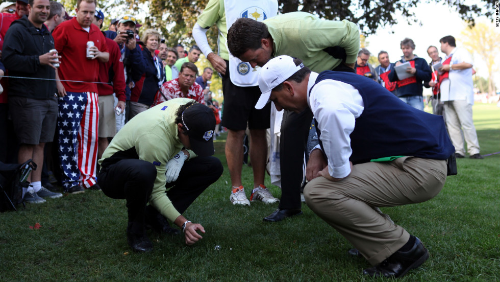 Rory McIlroy and Graeme McDowell of Europe get a ruling on their ball on the 18th hole Friday.