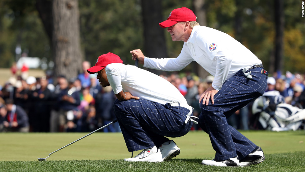 Tiger Woods and Steve Stricker line up a putt during the morning foursome matches on Friday.