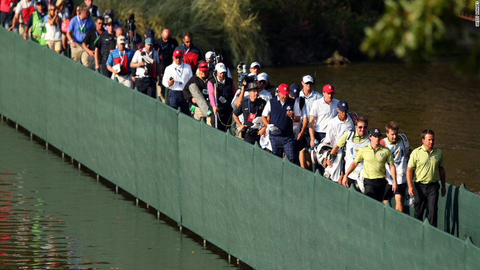 McIlroy and McDowell walk across a bridge ahead of the gallery on Friday.