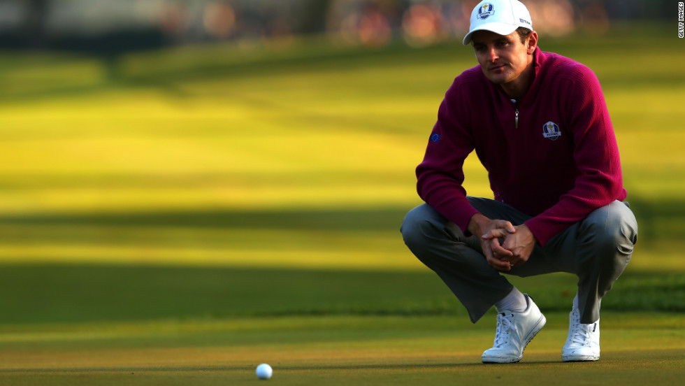 Golfer Justin Rose of Europe lines up a putt on the first green.