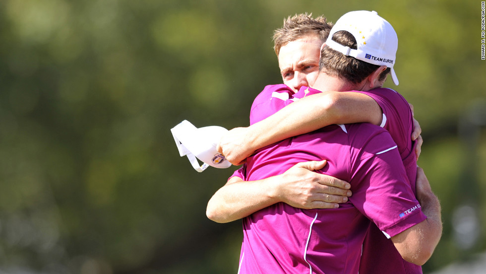 Poulter and Justin Rose of Team Europe embrace after winning their match on Saturday.