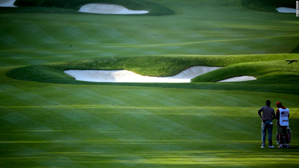 Webb Simpson of the United States waits in the fifth fairway with his caddie Paul Tesori on Saturday.