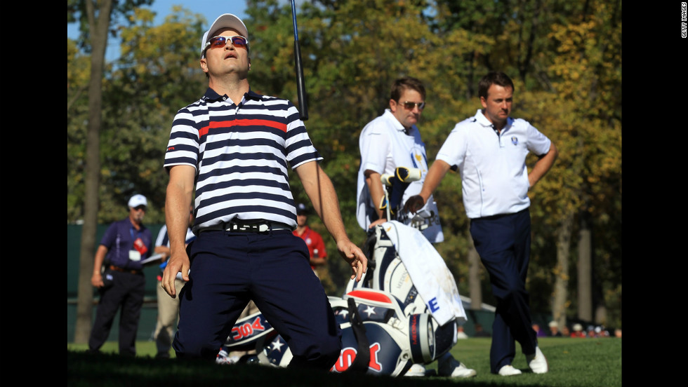 Zach Johnson of the United States reacts to a shot on the ninth hole Sunday as Graeme McDowell, right, and his caddie, Ken Comboy, of Europe look on.