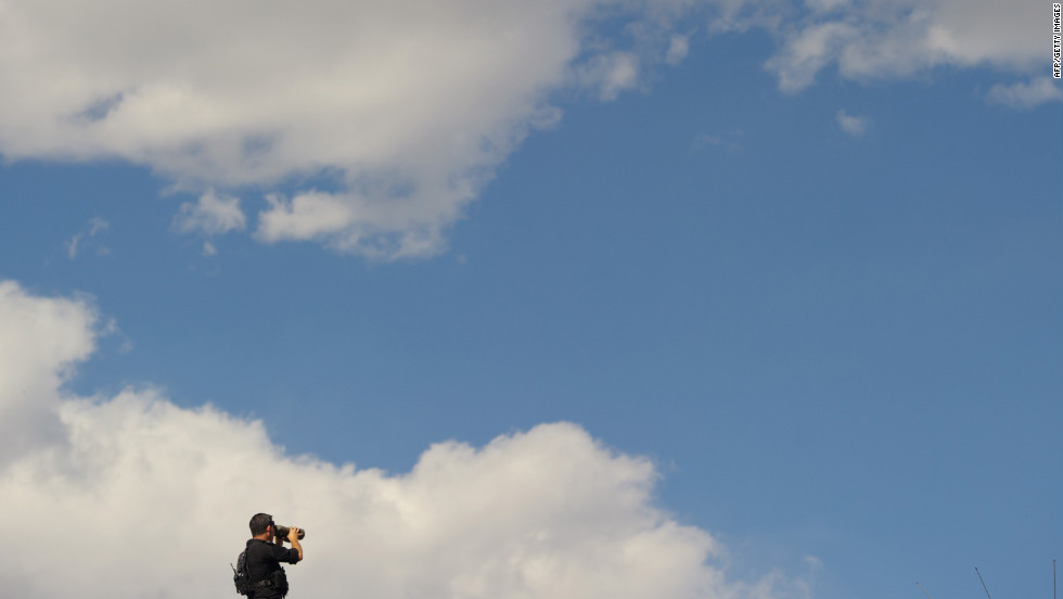 A member of the U.S. Secret Service keeps watch from the top of a building as Obama takes part in a debate walk-through at the University of Denver on Wednesday. 