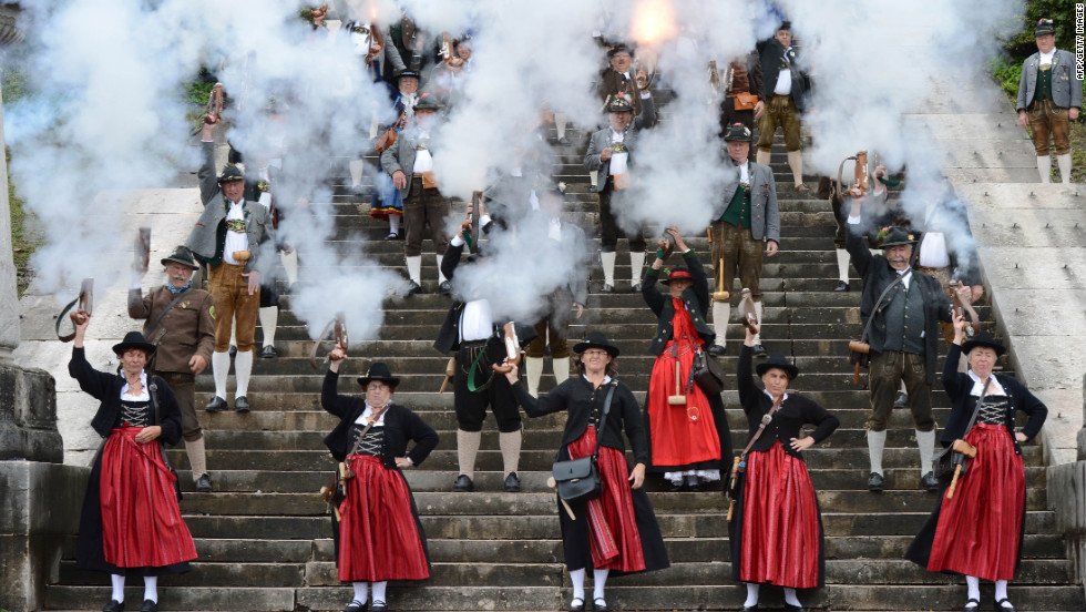 People in traditional Bavarian garb fire a salute Sunday on the steps of the Bavaria monument.