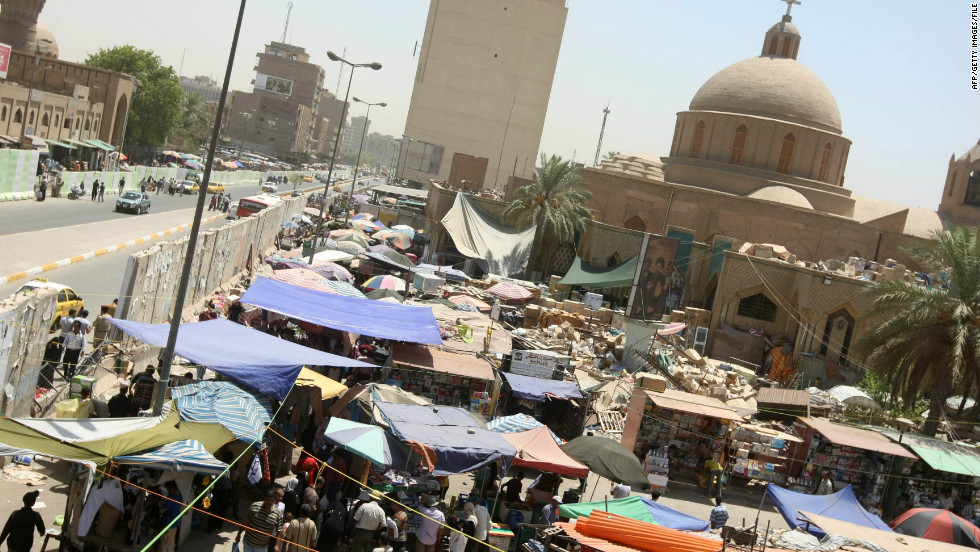 Markets in Baghdad (this one in 2010) are sometimes held in the shadows of blast walls in an effort to prevent suicide car bombings.