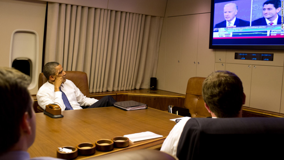 President Barack Obama watches the vice presidential debate aboard Air Force One with staff while heading home from Florida on Thursday.