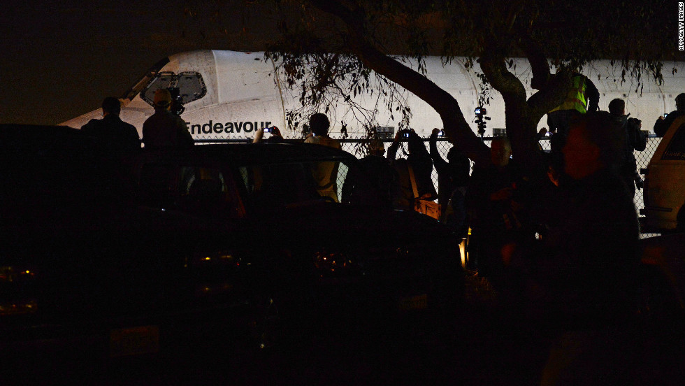 Members of the crowd reach over a fence for a glimpse of the shuttle. Endeavour, along with Discovery, Enterprise and Atlantis, became a museum piece after NASA ended its 30-year shuttle program last year. All four shuttles have been permanently retired from service.