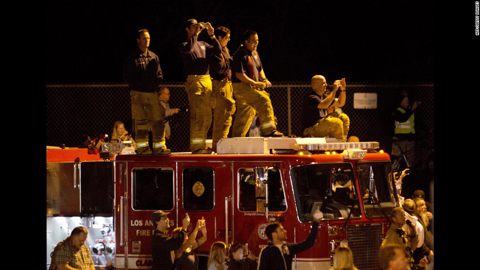 Firefighters and other spectators document the move early Friday. 