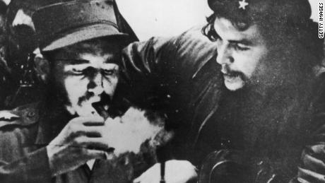 Fidel Castro lights his cigar while Argentine revolutionary Che Guevara looks on in the early days of their guerrilla campaign in the Sierra Maestra Mountains of Cuba, circa 1956.