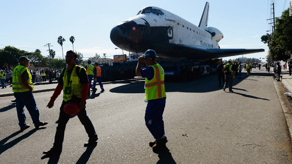 Workers escort Endeavour on its journey.