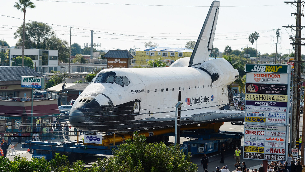 Endeavour makes its way past restaurants and shopping centers in Los Angeles.