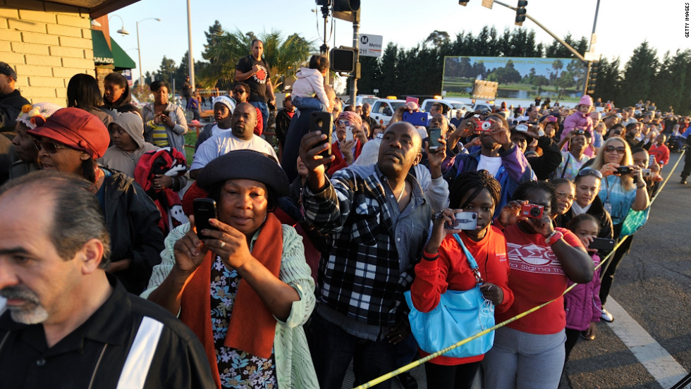 People watch as the space shuttle slowly moves along Manchester Boulevard in Inglewood on Saturday.