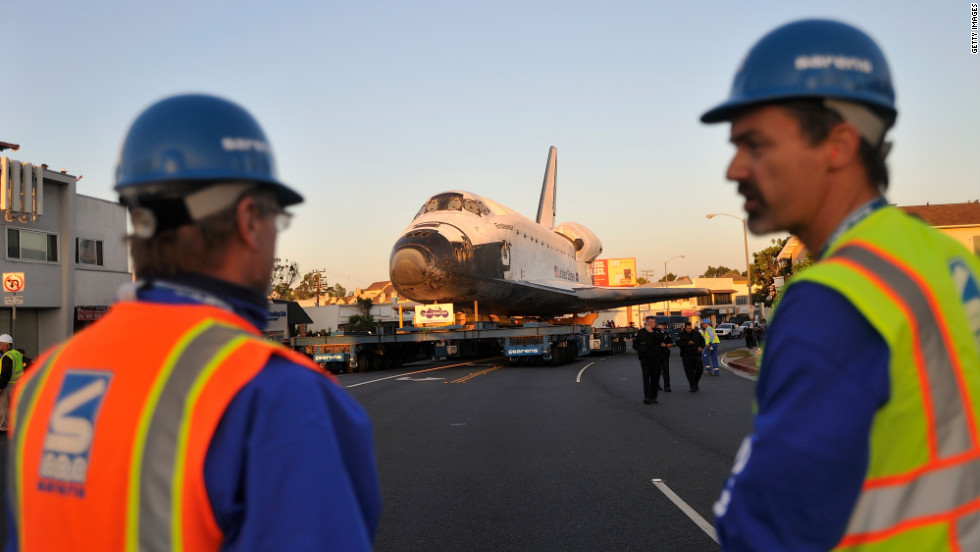 Workers talk as the shuttle moves along Manchester Boulevard on Saturday.