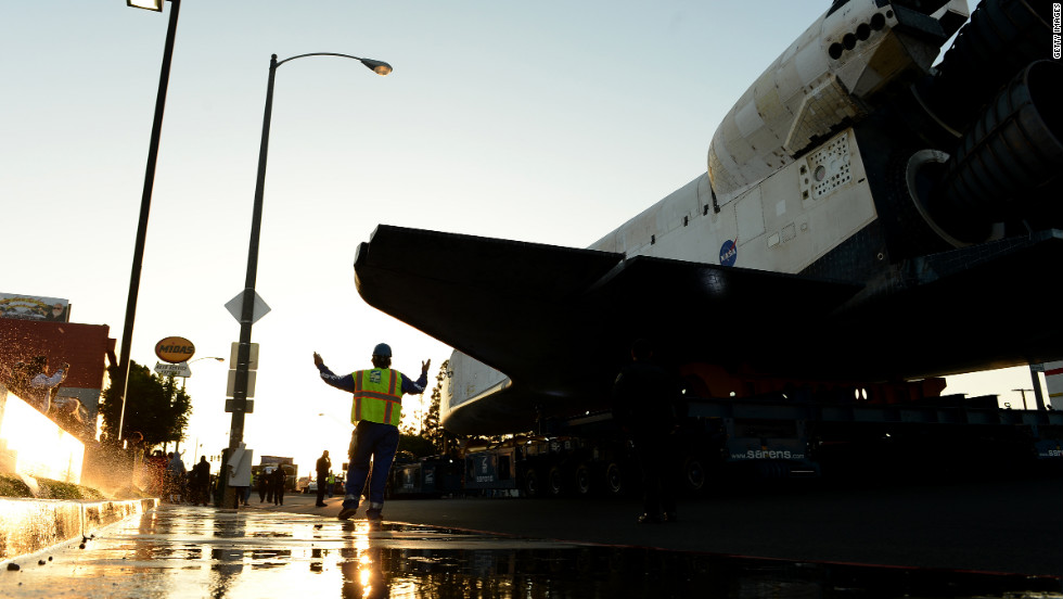 A worker accompanies the space shuttle Endeavour along Manchester Boulevard. 