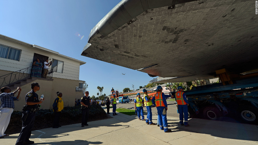 Endeavour squeezes through a neighborhood lined with apartment buildings on the narrowest part of its journey on Saturday.