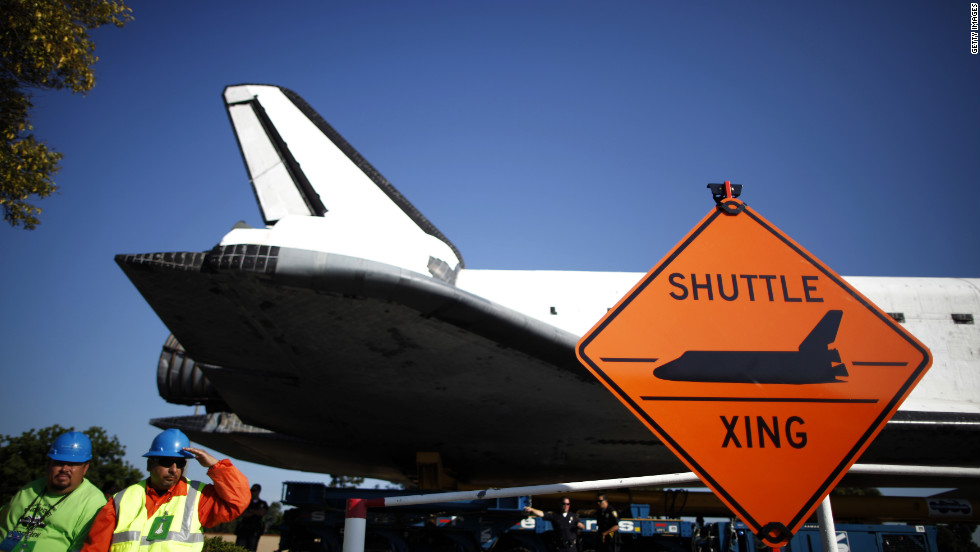 The space shuttle Endeavour passes a &quot;Shuttle crossing&quot; sign on its way to the California Science Center on Saturday in Inglewood, California. 