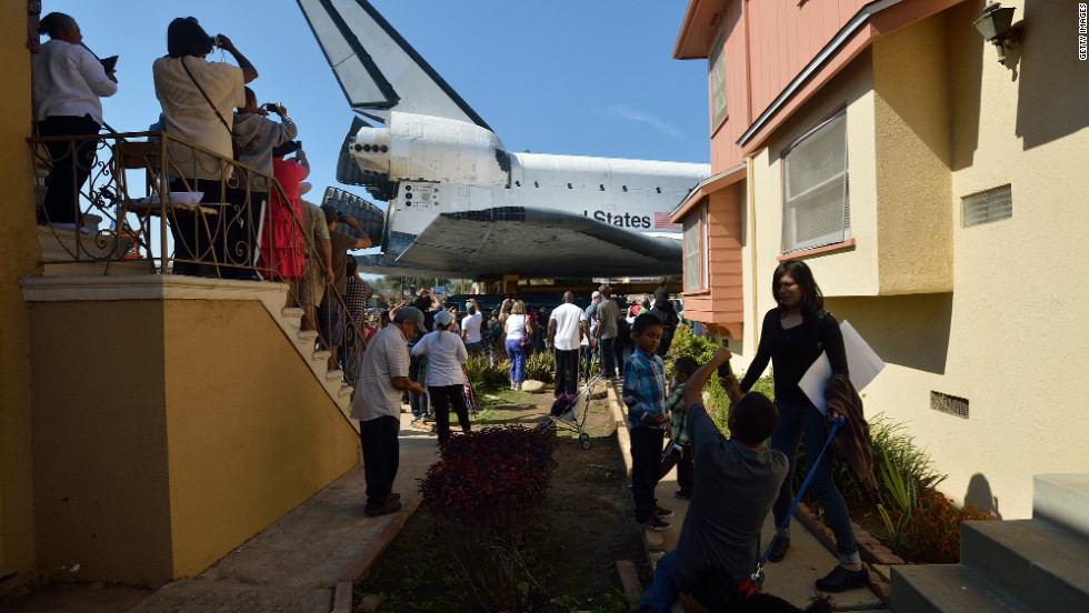 People watch Endeavour pass residential buildings on Crenshaw Drive. Over two days, the 170,000-pound shuttle will travel at no more than 2 mph along a 12-mile route from Los Angeles International Airport to its final home.