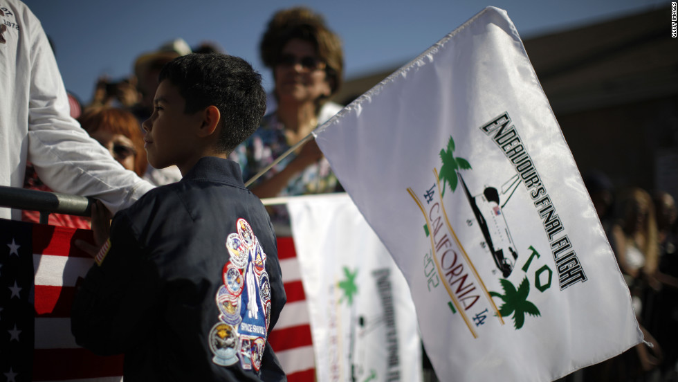 Kevin Alcaraz, 8, waves a flag from the crowd gathered along the shuttle&#39;s route.