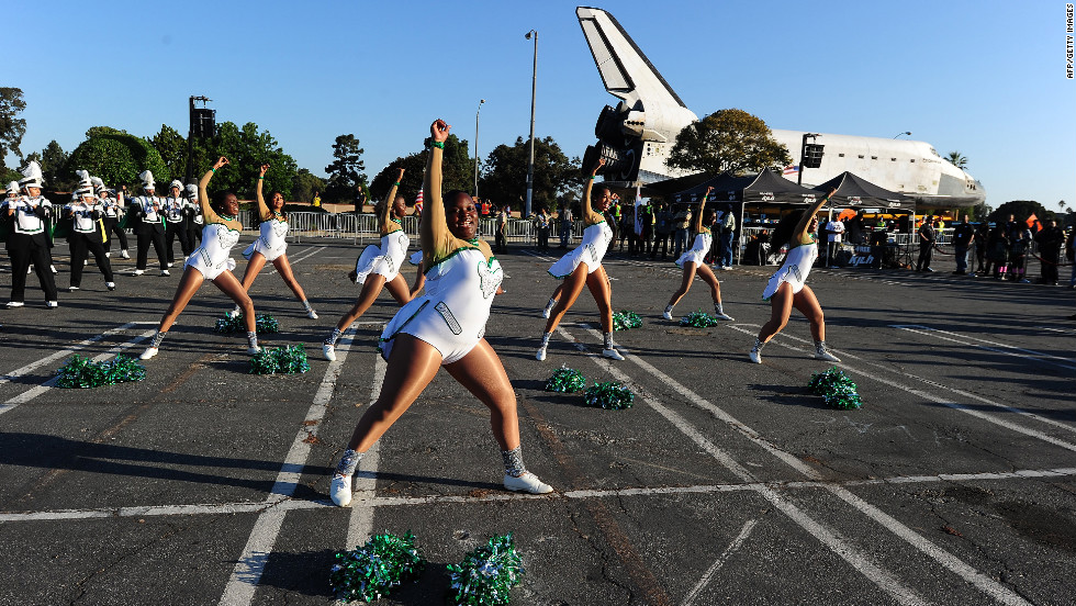 Inglewood High School cheerleaders perform near the shuttle on Saturday.