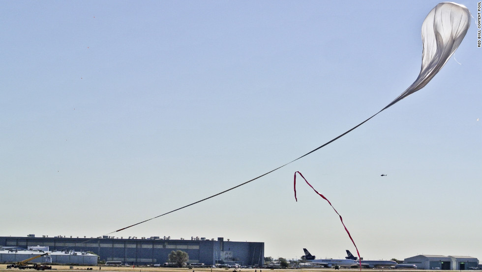 A crane carrying the capsule follows the helium balloon during the launch on Sunday.