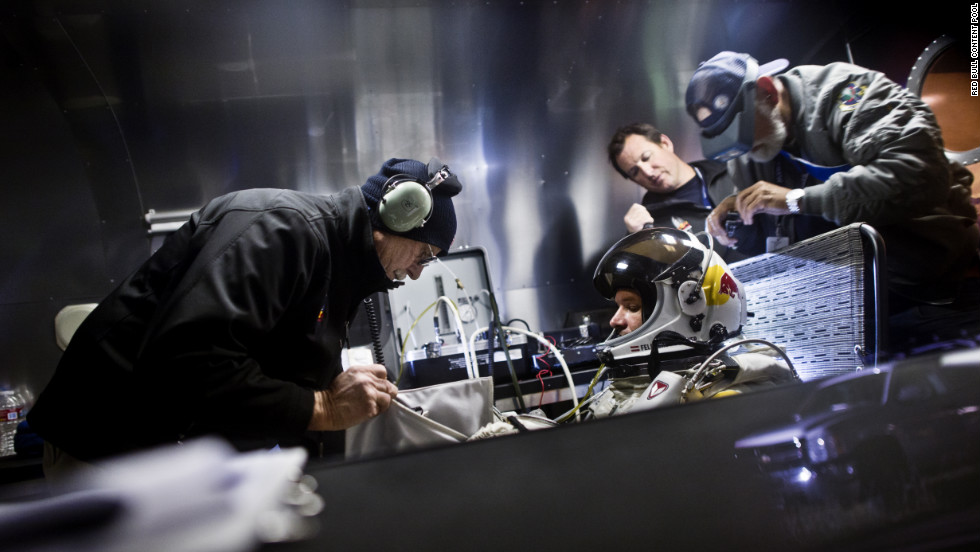 Crew members assist Baumgartner in his trailer. The Red Bull Stratos team includes a former NASA crew surgeon, record-breaking aviators and innovative aircraft designers.