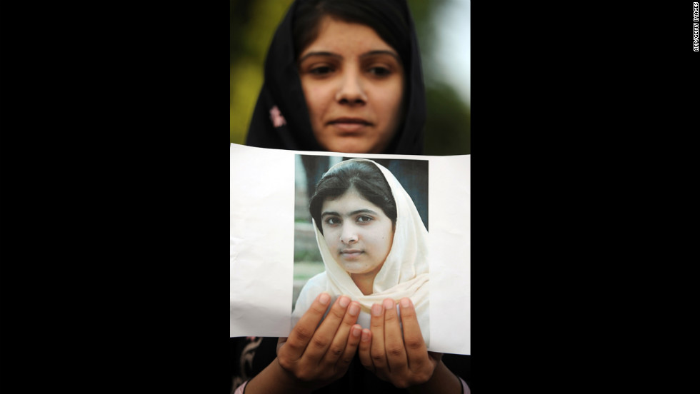 A Pakistani female activist holds a photograph of Malala and prays for her recovery in Islamabad on Saturday.