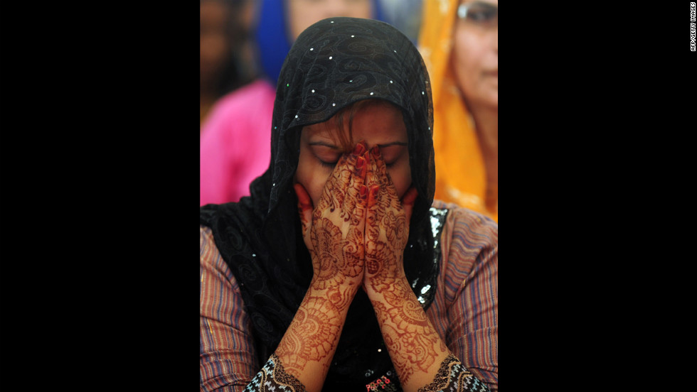 A Pakistani female covers her face during prayers in Karachi.