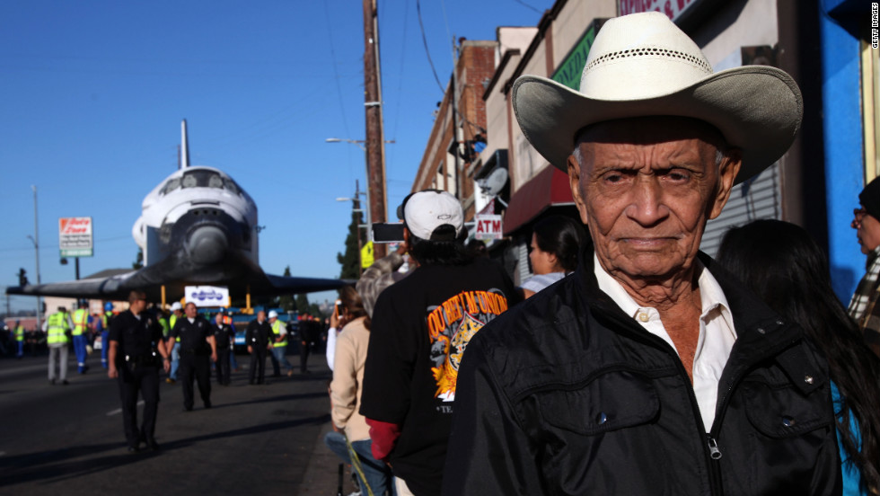 Federico Gonzales is among the many spectators as Endeavour inches down Martin Luther King Boulevard in Los Angeles on Sunday.