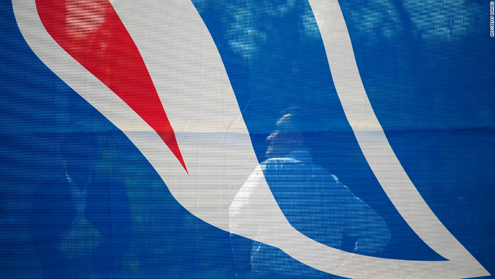 Mitt Romney is seen backstage through a campaign flag as he waits to take the stage at a rally in Chesapeake, Virginia, on Wednesday.