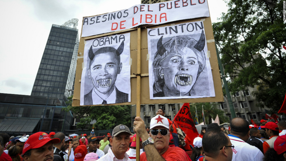 Despite Chavez&#39;s recent endorsement of Obama, not everyone approves of the job Washington is doing. Here, protesters hold a poster reading &quot;killers of Libyan people&quot; with portraits of Barack Obama and Hillary Clinton in Caracas, Venezuela, on April 13, 2011.