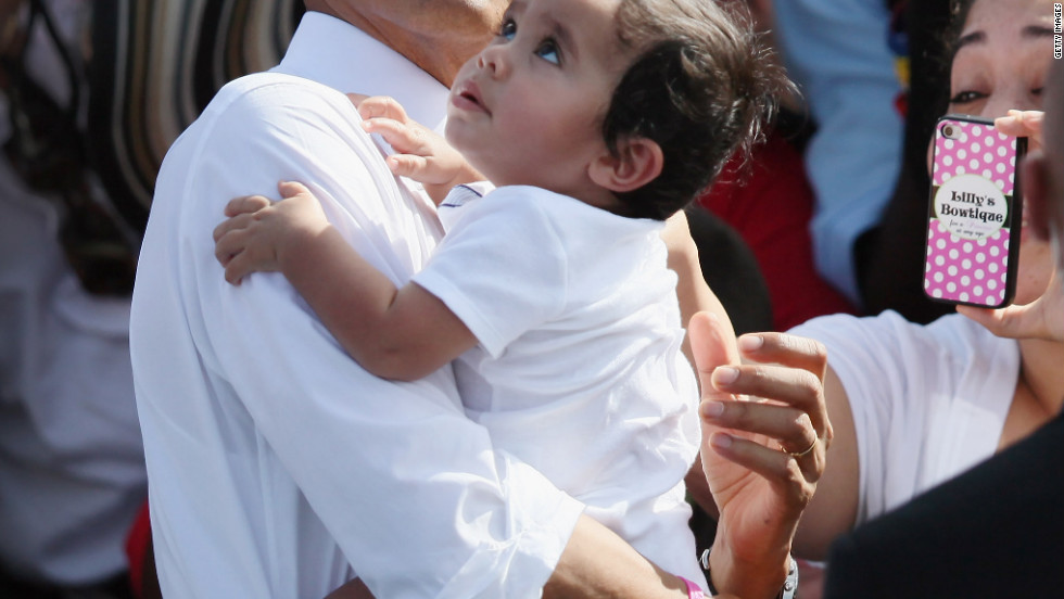 President Obama holds a baby as he greets people during a campaign rally at the Delray Beach Tennis Center on Tuesday, October 23, in Delray Beach, Florida. Obama continues to campaign across the United States in the run-up to the November 6 presidential election.