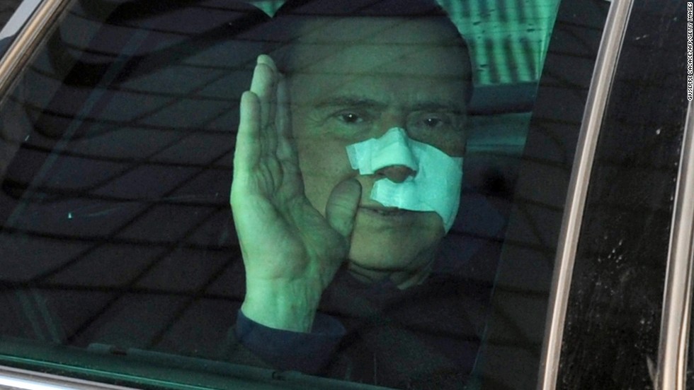 Berlusconi waves to journalists as he leaves a Milan hospital in December 2009 after suffering severe facial wounds in an attack at a rally.