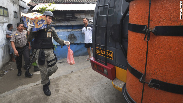 A police officer carries belongings from the house of a suspected militant after a raid in Jakarta on Saturday.