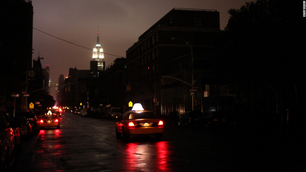 Taxis drive down a New York street where the power was out late Monday, October 29.