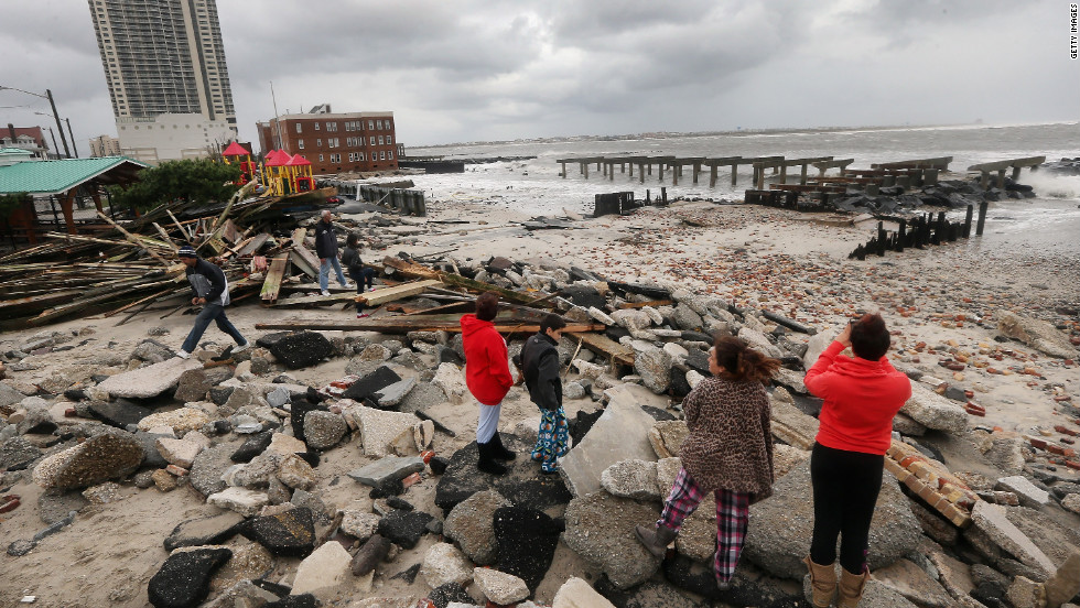 People stand among the debris of the destroyed section of Atlantic City, New Jersey&#39;s, uptown boardwalk on Tuesday.