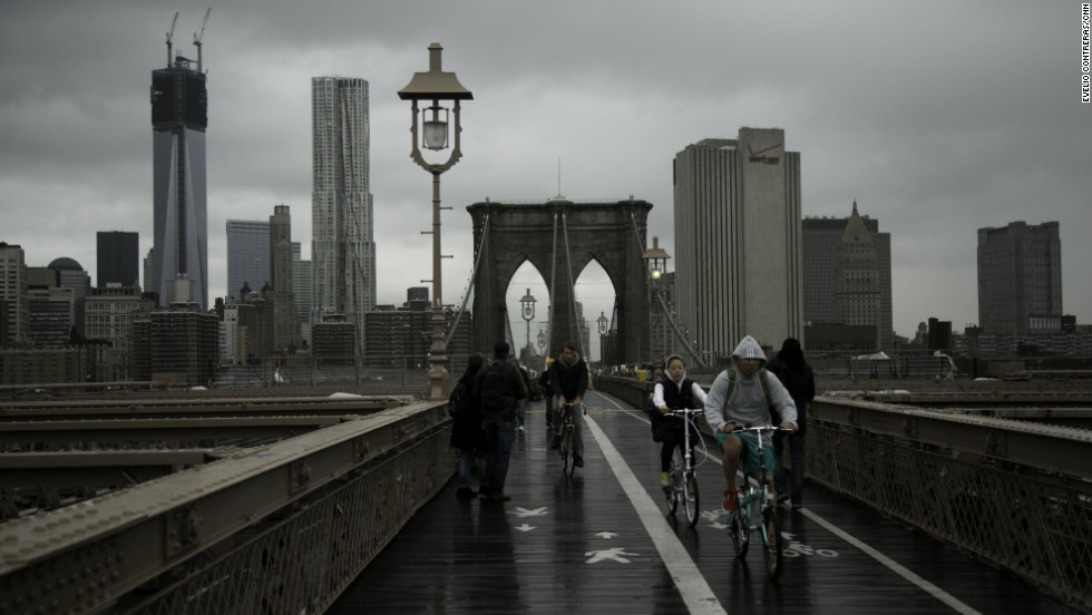 Pedestrians and bikers cross the Brooklyn Bridge after the storm on Tuesday.
