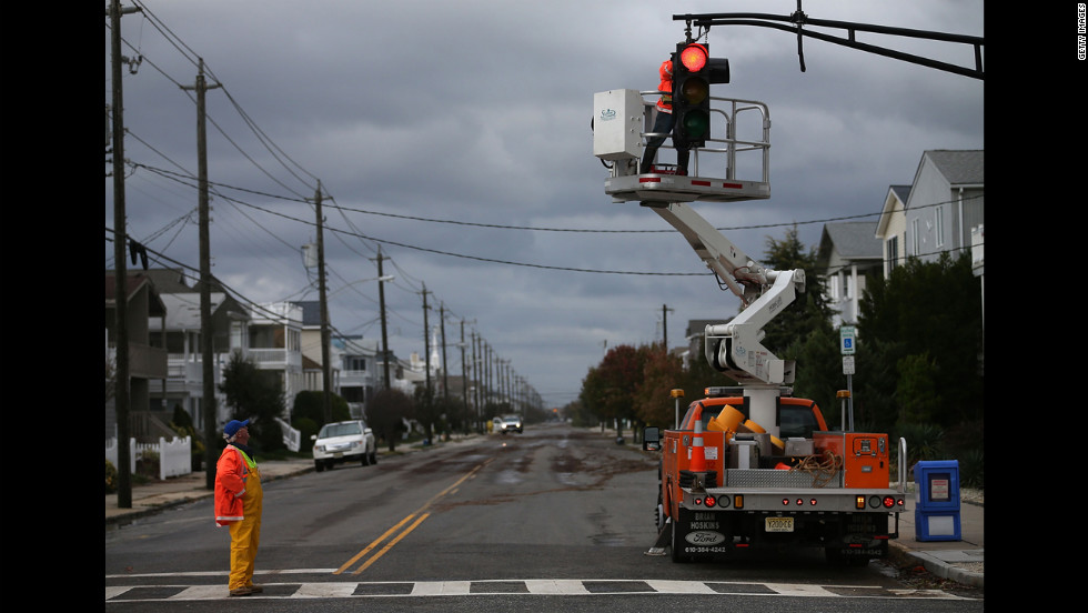 Utility workers repair a traffic signal damaged by the storm in Ocean City, New Jersey, on Tuesday.