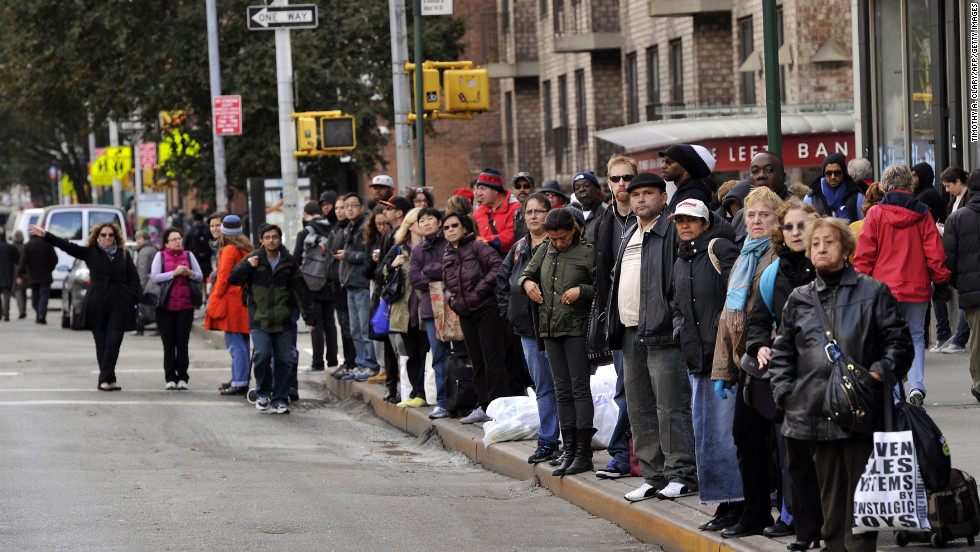 People wait for buses along  New York&#39;s Sixth Avenue on Wednesday.