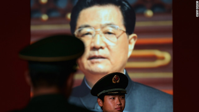  A paramilitary policeman passes by the portrait of China&#39;s President Hu Jintao at a state-sponsored exhibition in Beijing Tuesday.