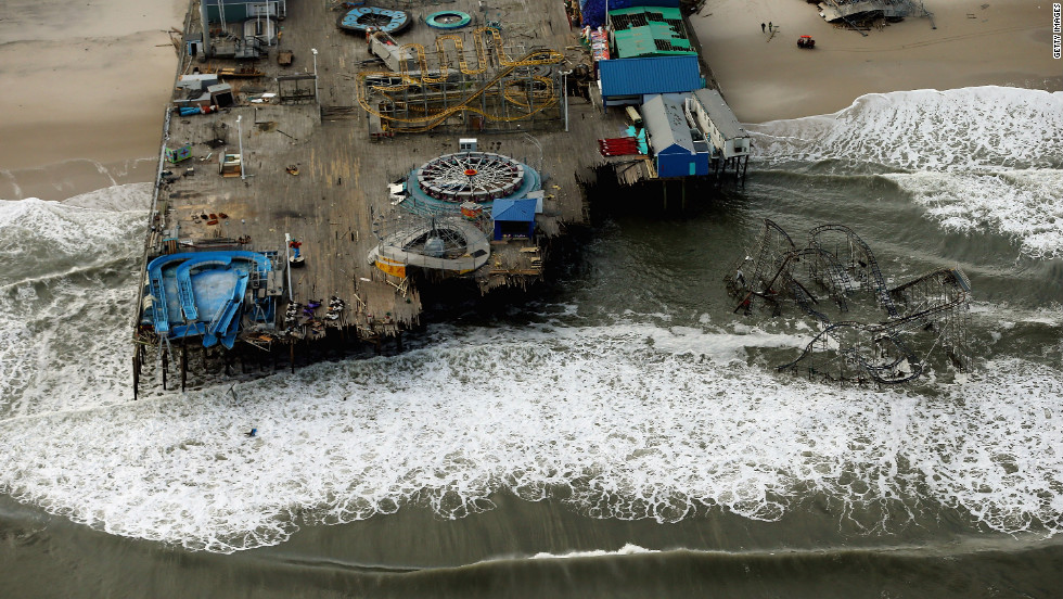 Waves break in front of an amusement park destroyed by Superstorm Sandy on Wednesday, October 31, in Seaside Heights, New Jersey. At least 56 people were killed in the storm. New Jersey suffered massive damage and power outages. 