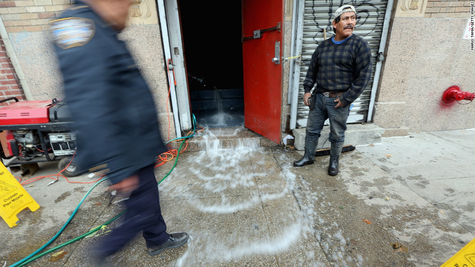 Water gets pumped out of a business in the East Village on Thursday.