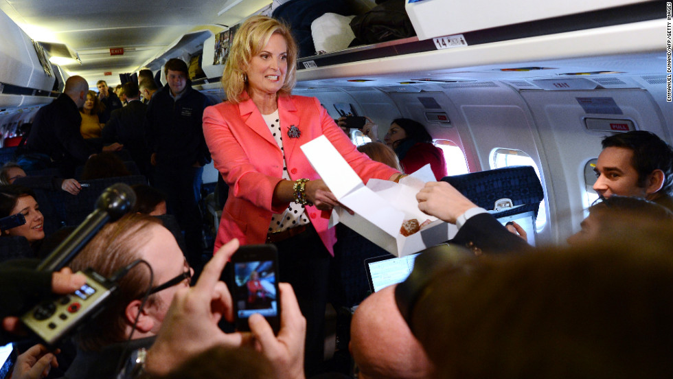 Ann Romney offers pastries to journalists aboard GOP presidential candidate Mitt Romney&#39;s campaign plane at Portsmouth International Airport in Newington, New Hampshire, on Saturday.