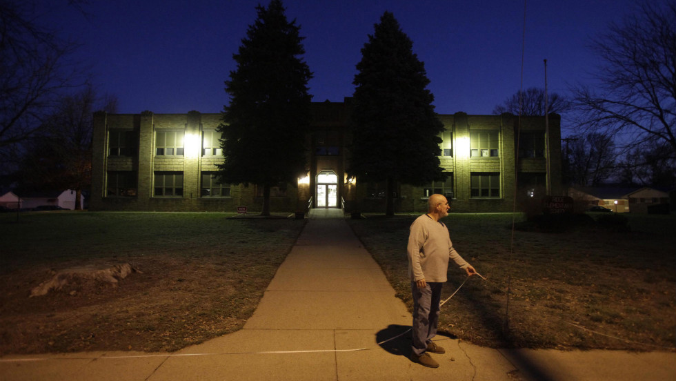 Poll worker David Smith used a tape measure to mark a boundary at a Bowling Green, Ohio, school to keep local politicians 100 feet away from where voters cast ballots. 