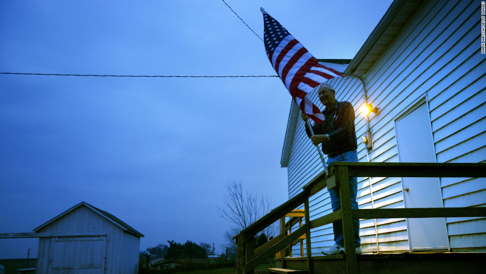 Election inspector Jim Nodorft prepared to hang the U.S. flag outside the Smelser Town Hall as polls opened at 7 a.m. in Georgetown, Wisconsin.