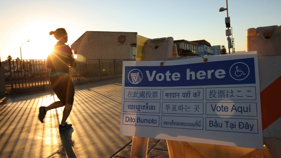 A jogger on The Strand in the Los Angeles area community of Hermosa Beach passed a directional sign to a polling place at sunrise.