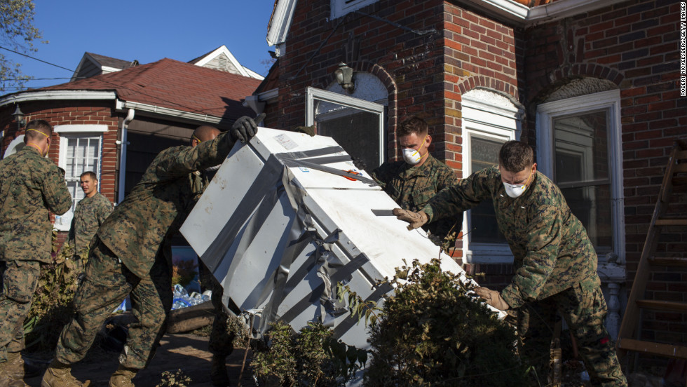 Troops from the 26th Marine Expeditionary Unit and the U.S. Navy help local residents remove household items damaged by Superstorm Sandy on November 6, in the New Dorp Beach neighborhood of Staten Island, New York.