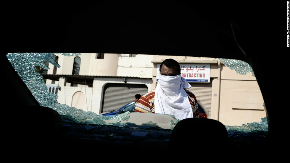 A Bahraini Shiite man inspects his car, which was damaged during clashes between riot police and protesters. 