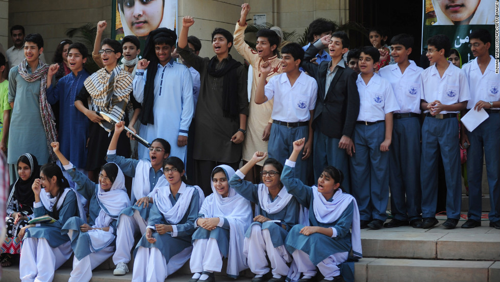 Pakistani students shout slogans near photographs of Malala in Karachi on Saturday.